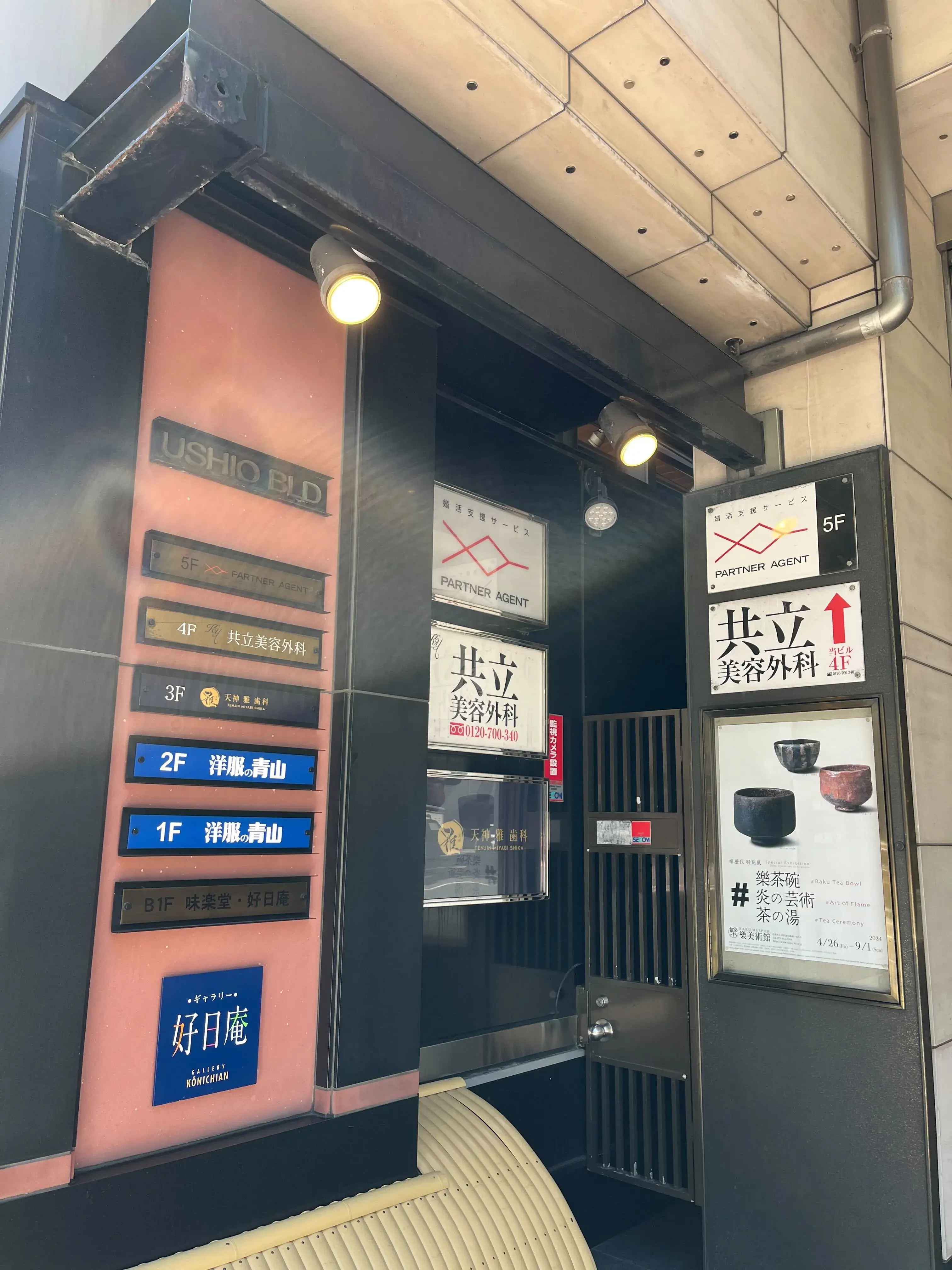 ⑥到着 USHIOビルの入り口です。看板が左手に見えます。エレベーターで4Fまでお越し下さい。（
