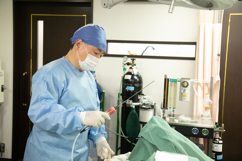 脂肪を吸引する医師