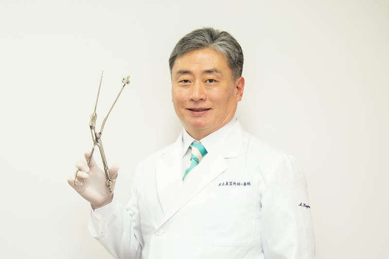 ローラークランプという医療器具を手に持っている美容外科医