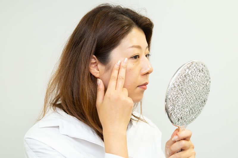 目の下のふくらみを予防をする女性