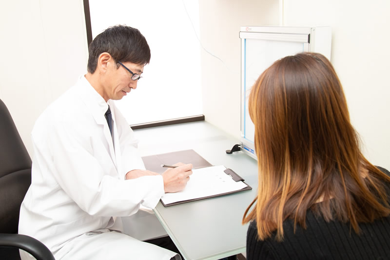ピアスの穴開けについてカウンセリングしている医師と患者