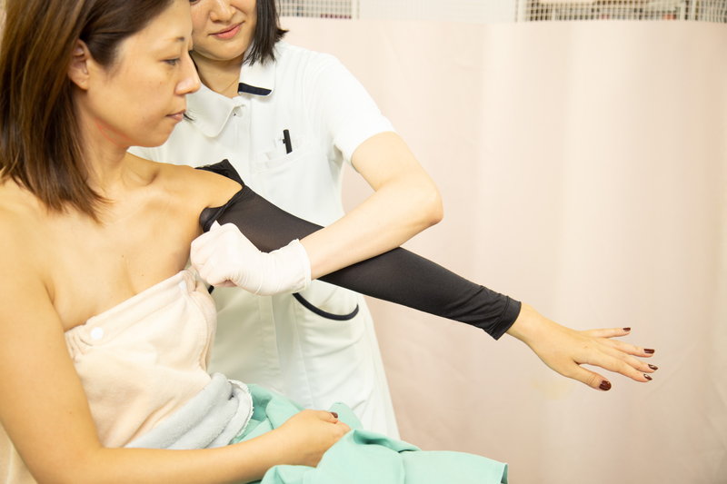 二の腕の脂肪吸引をしている後にガードルをはめているところ