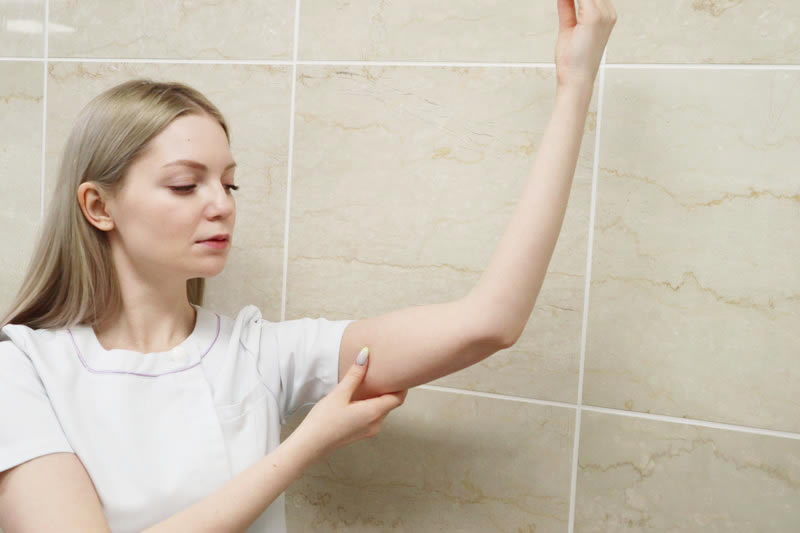 二の腕マッサージする女性