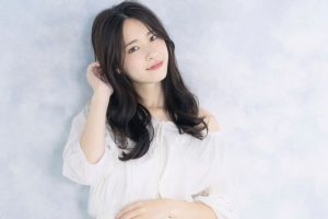 壁際でポーズをとっている女性