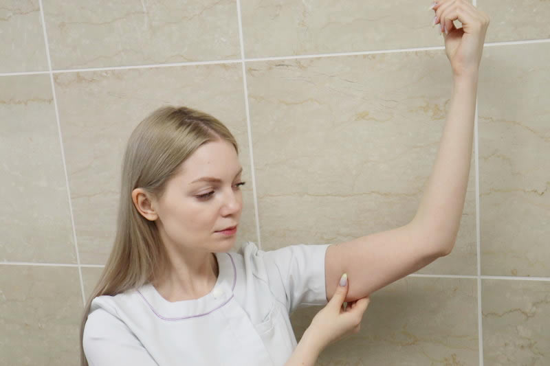 腕のたるみを細くする方法を説明する看護師