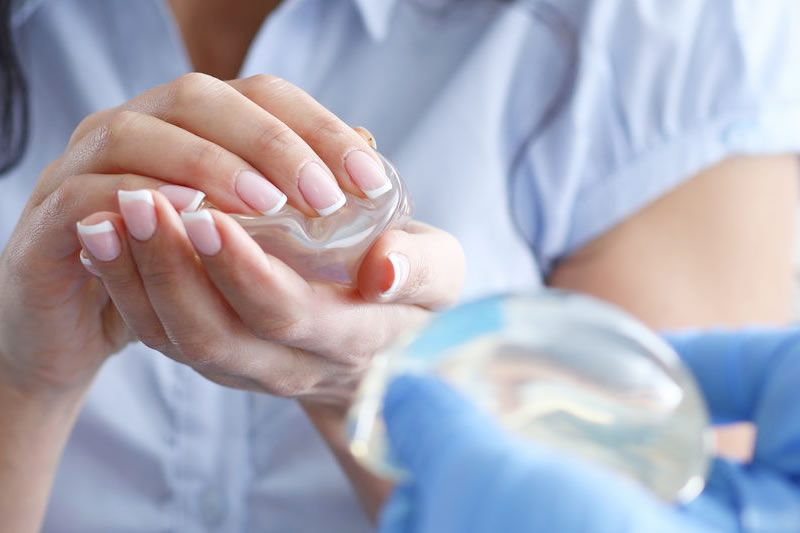 豊胸バッグを除去しようか医師と相談している患者