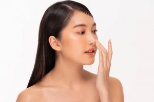 鼻を指さす女性
