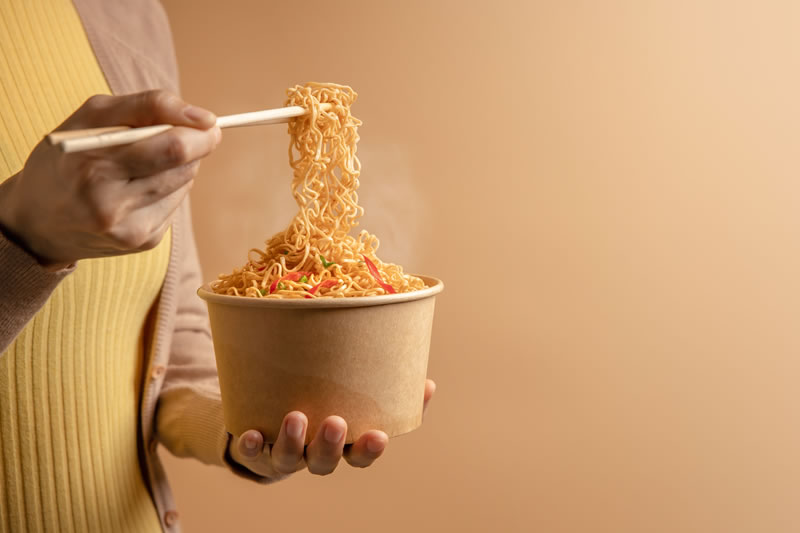 ラーメンを急いで食べている女性