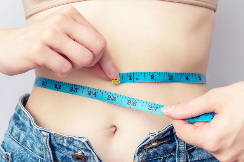 腹囲のサイズを測っている女性