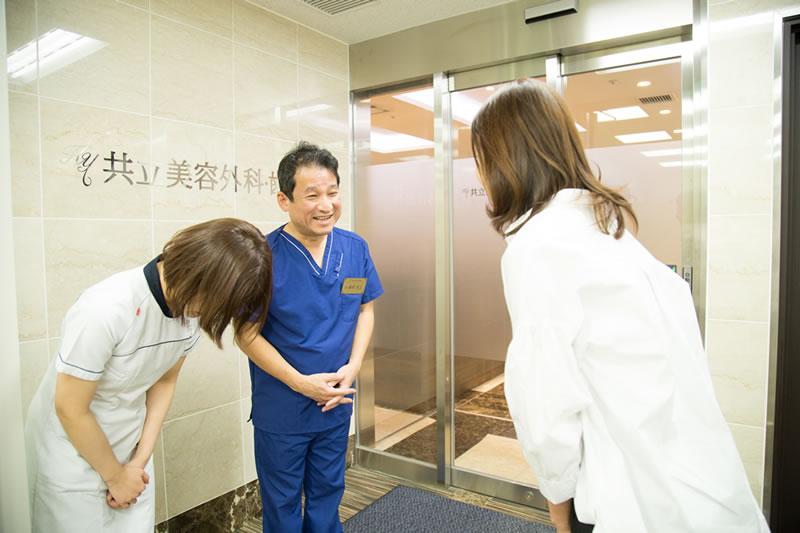 共立美容外科のエントランスで挨拶する医師と患者