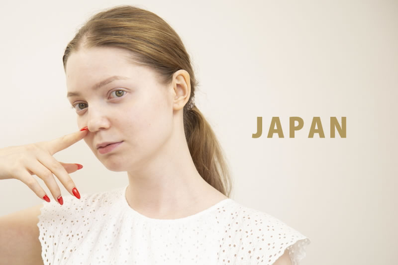 鼻を指さす女性
