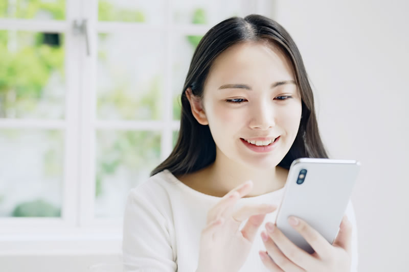 スマフォで口コミをチェックする女性