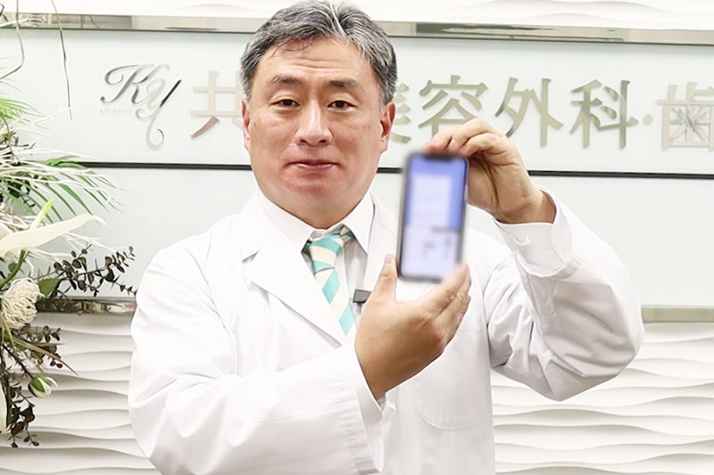 スマフォを手に取る医師