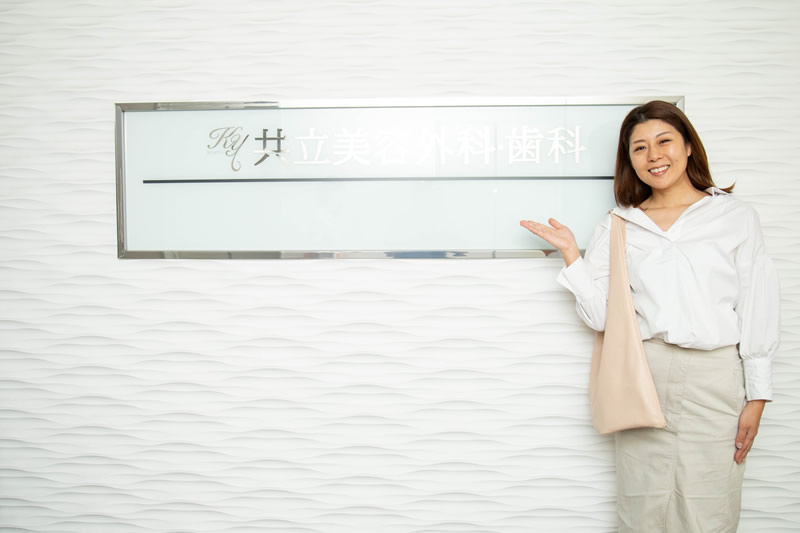 共立美容外科の前で写真を撮る女性