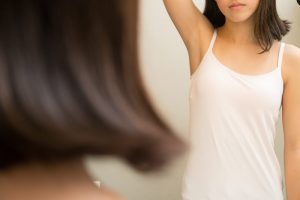 女の子が鏡の前で手を挙げているところ