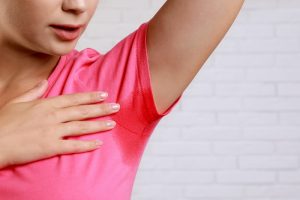 女性のTシャツの脇に汗がにじんでいるイメージ