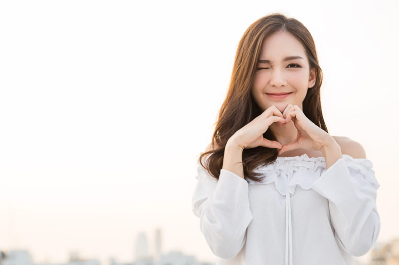手でハートを作っている女性