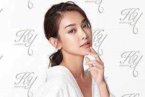 指を口もとに置いている女性