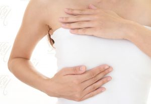 胸元に両手を当てる女性のイメージ