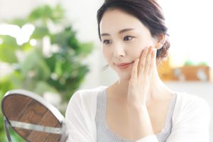 鏡で自分の顔を確認している女性