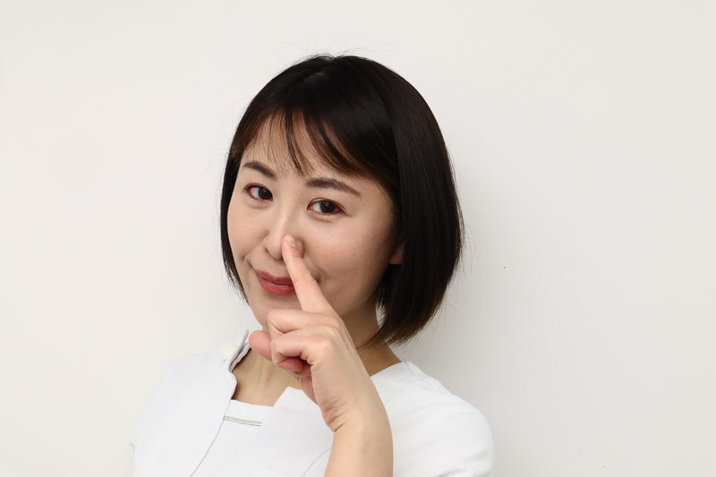 鼻を指さす女性