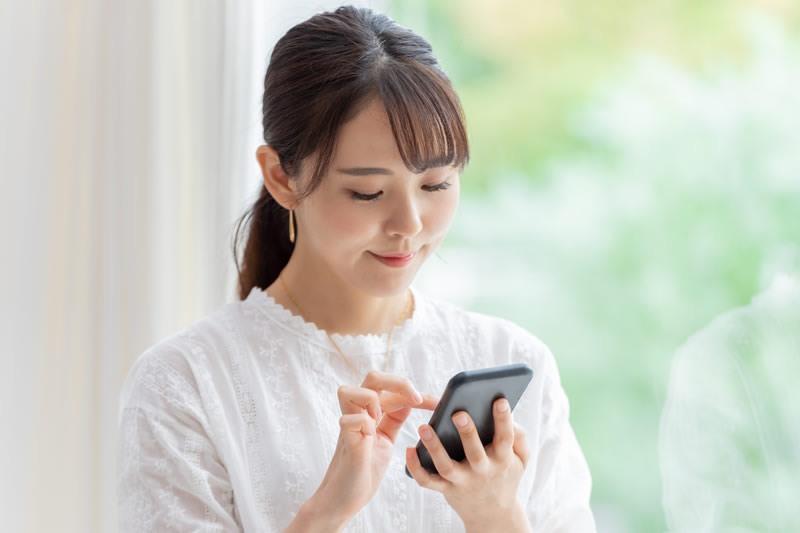 スマフォで二重の失敗例を調べる女性