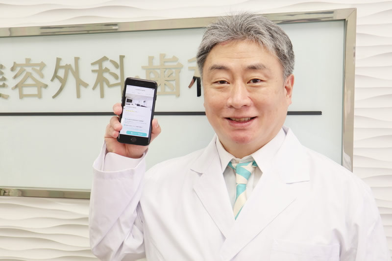 トリビューのスマフォ画面を見せる医師