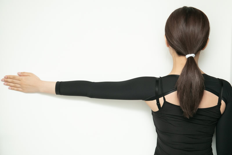 二の腕に圧迫用のサポーターをつけている女性