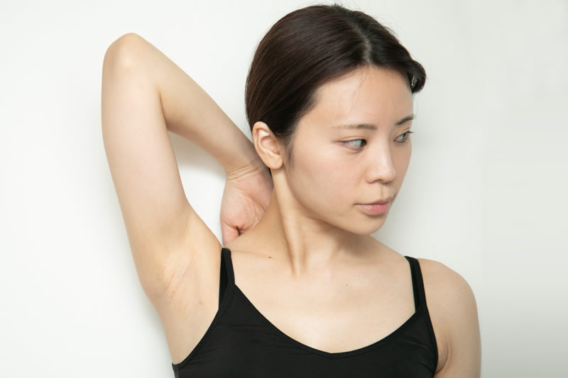 二の腕のたるみを見せる女性