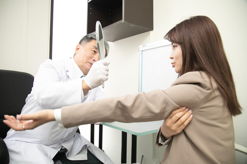 医師に二の腕の脂肪吸引を相談する女性