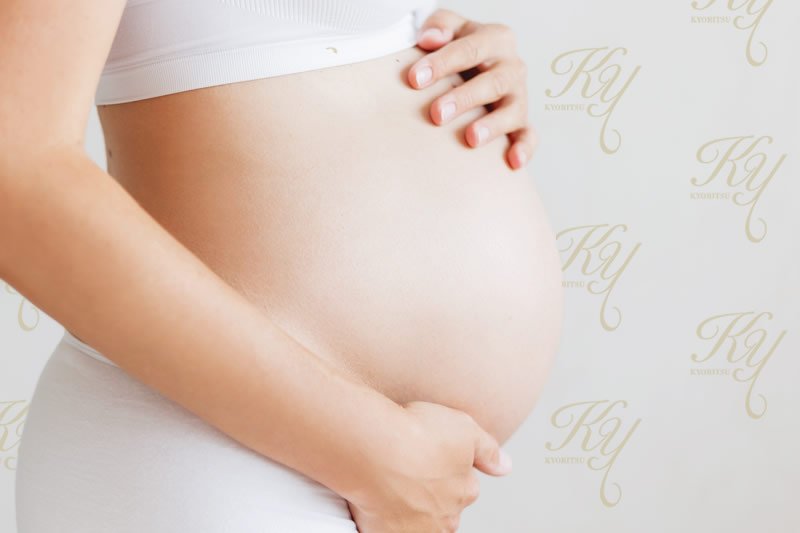 妊婦がお腹を抱えているところ