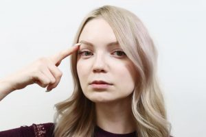 目を指で指している女性