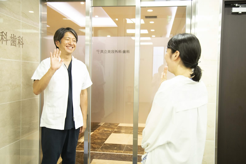 美容外科の前で挨拶する医師と患者