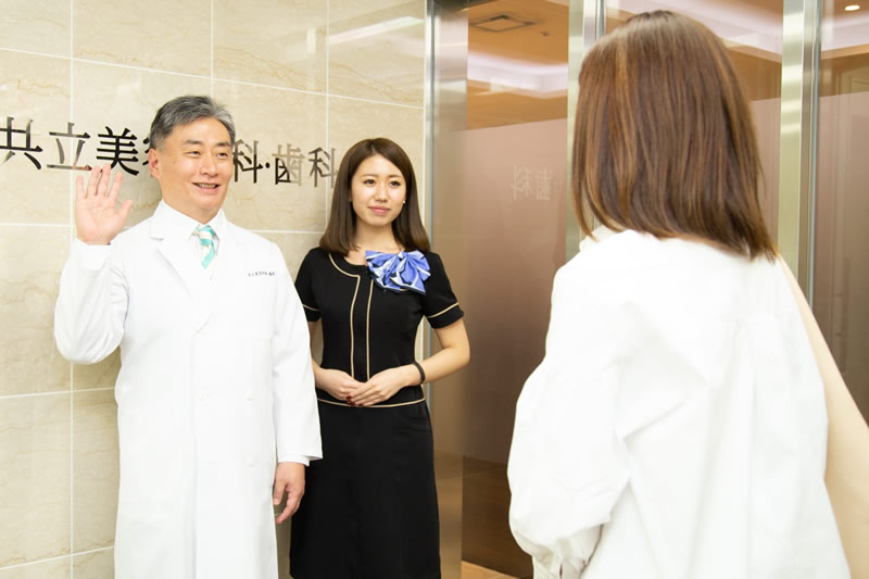 美容外科の前で挨拶する医師と患者