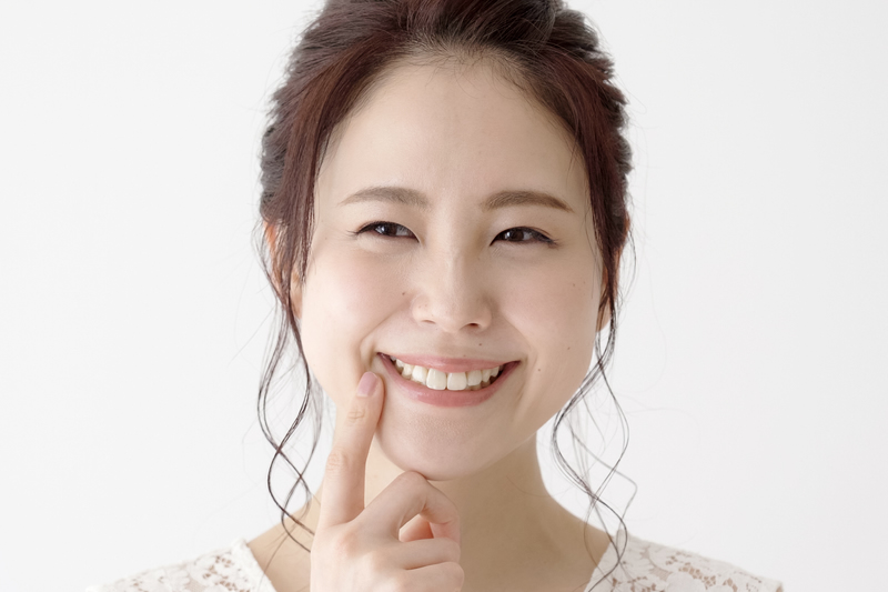 口角を上げるフェイストレーニングをしている女性