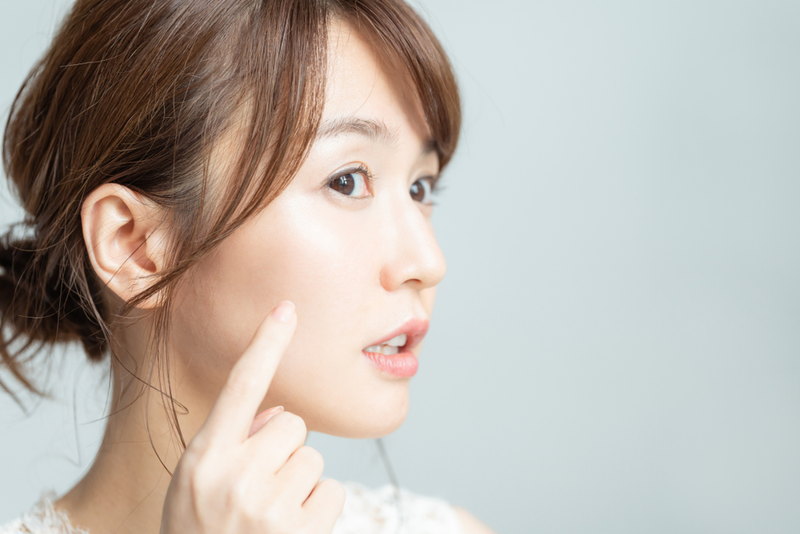 肌を指さす女性