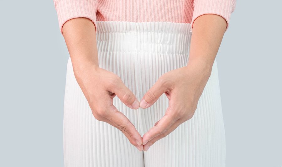 股の前でハートの形を作る女性