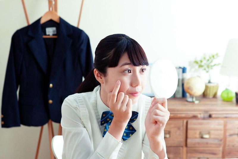 自宅でニキビを気にしている女子高生