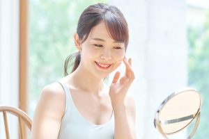 鏡で顔を見ている女性