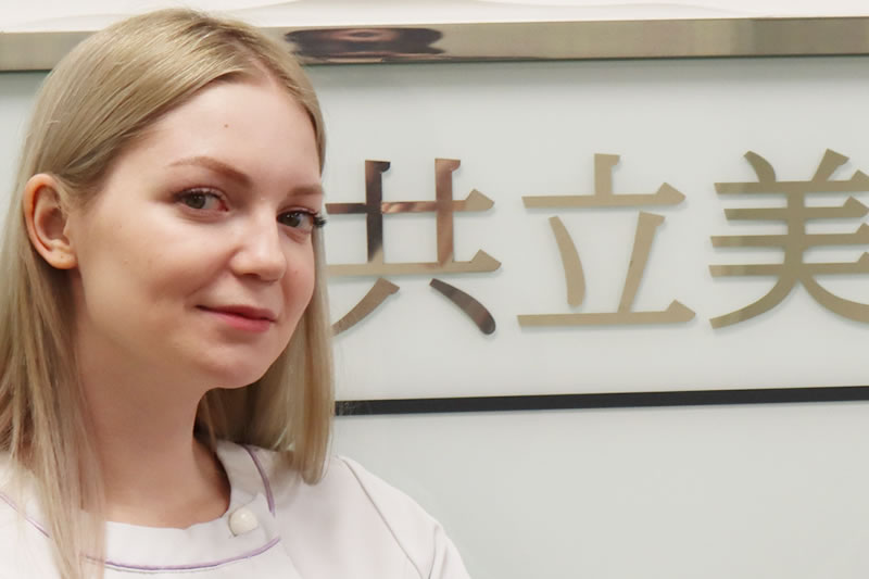 共立美容外科の入り口の前に立つ看護師
