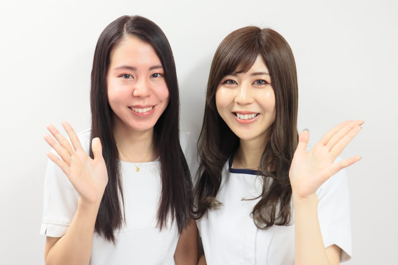 美容外科で受けられる毛穴トラブル治療を案内している2人の看護師