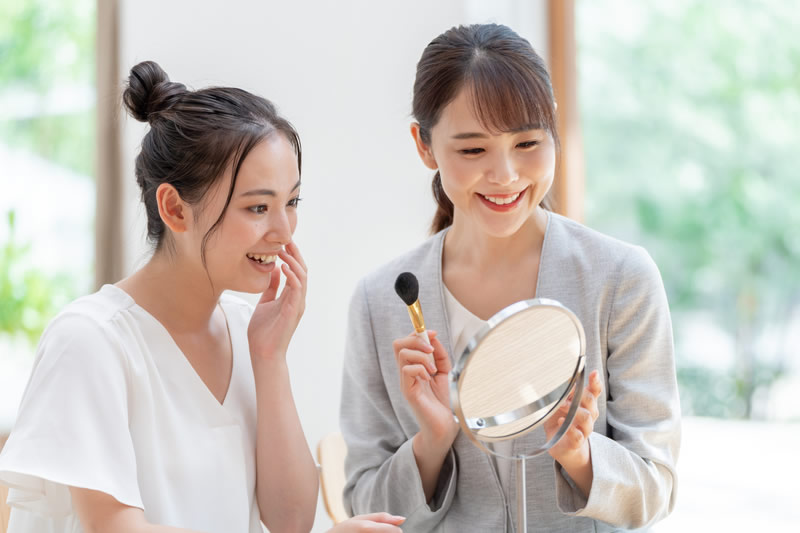 顔を小さく見せる髪型やメイクを教わっている女性