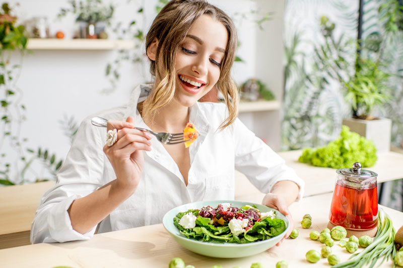 ビタミンが多い野菜を食べる女性