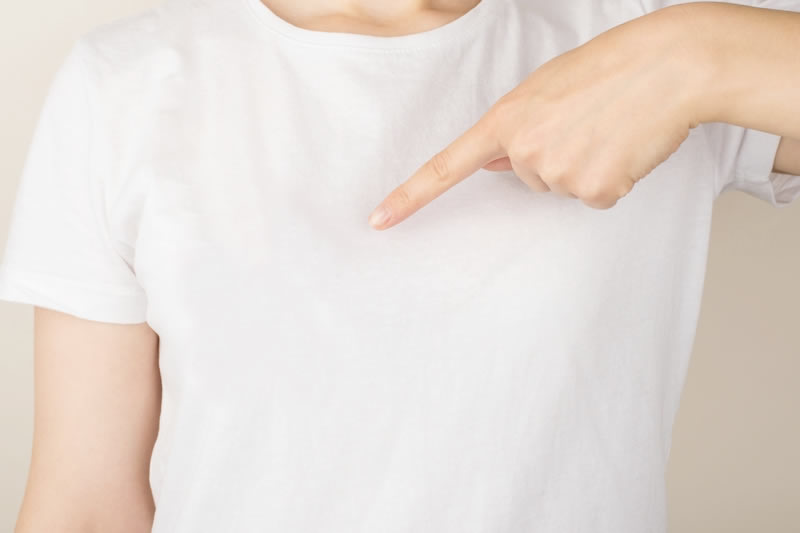 胸を指さす女性