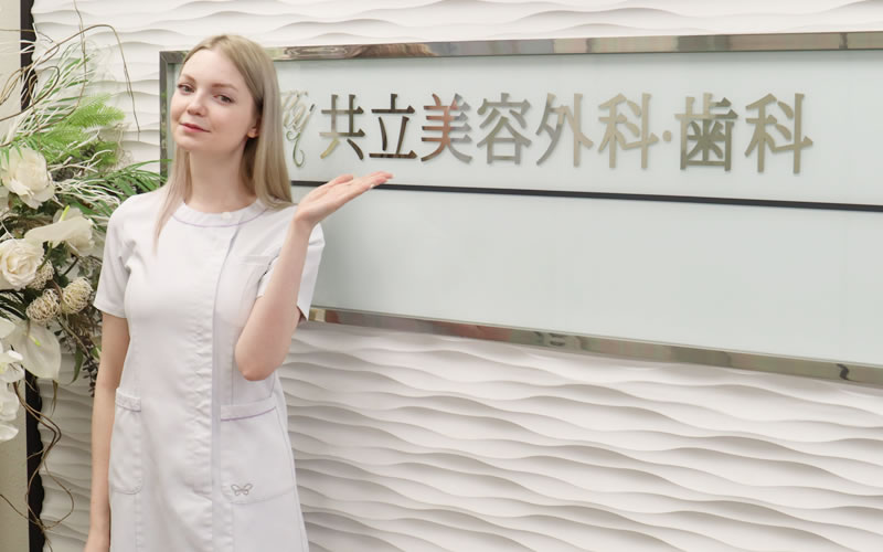 共立美容外科の入り口に立っている女性