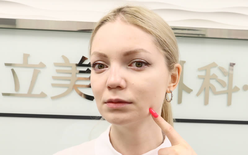 ほうれい線を指で指す女性