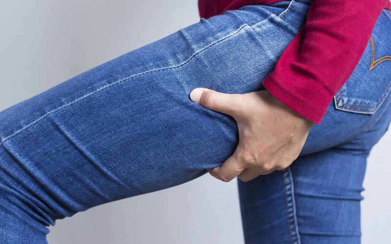 脚を細くするためのストレッチをしている女性