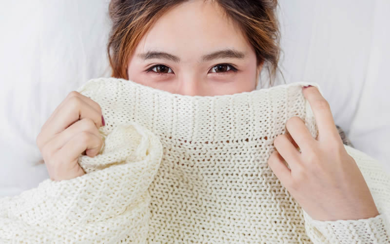 ニットで口元を覆っている女性