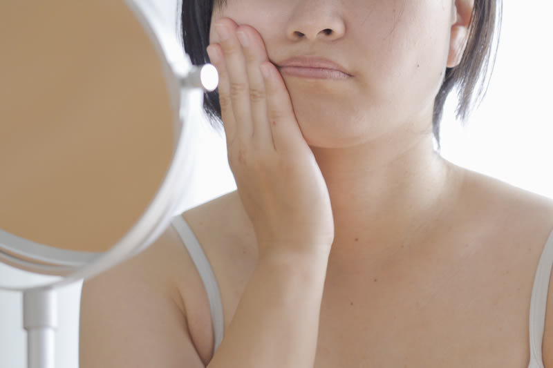 顔のむくみが気になる女性