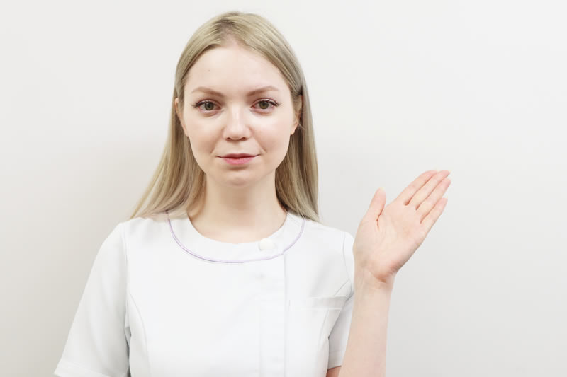 顔の脂肪吸引のダウンタイムについて説明している看護師